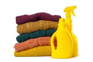 Stack of various sweaters isolated on white background photo