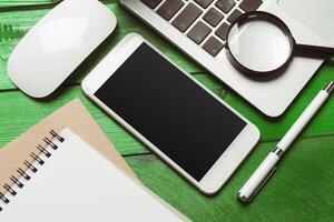 Office table with smartphone on it. View from above photo