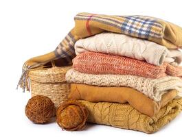 Stack of various sweaters isolated on white background photo