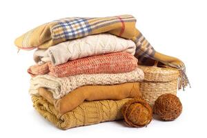 Stack of various sweaters isolated on white background photo