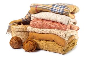 Stack of various sweaters isolated on white background photo