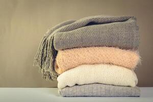 Stack of cozy knitted sweaters photo