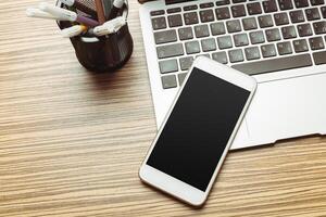 Office table with smartphone on it. View from above photo