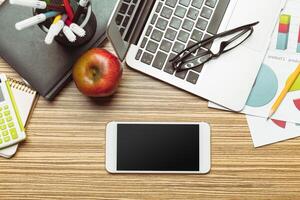 Office table with smartphone on it. View from above photo