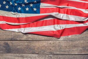 An American Flag Lying on an aged, weathered rustic wooden background photo