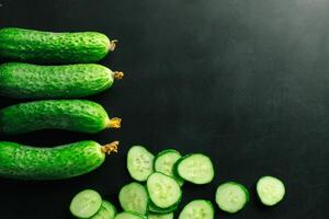 Fresh cucumber on black background photo