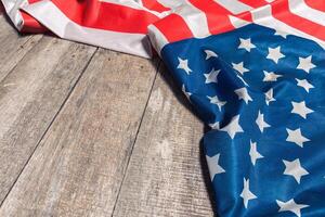 An American Flag Lying on an aged, weathered rustic wooden background photo