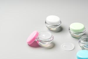 Colorful cosmetic containers arranged neatly on a light gray background photo