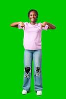 Smiling young woman pointing downwards against a bright green background photo