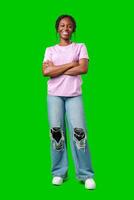 A joyful young woman smiling brightly while standing against a vivid green background photo