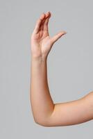 Raised hand against a neutral background in a softly lit setting photo