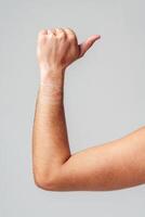 A person hand gesture against a neutral background photo