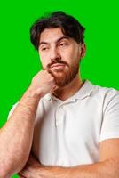 A man with a serious expression stands against a vibrant green background photo