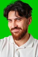 A man with a beard smiles confidently against a bright green background photo