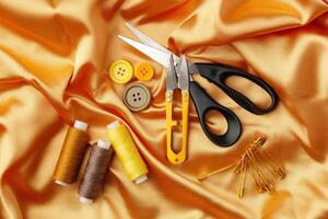 Crafting essentials arranged on golden satin fabric with sewing tools and colorful buttons scattered around photo