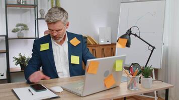 Tired sad exhausted businessman working on laptop at office with many sticker tasks, panic attack video