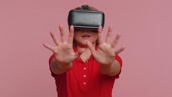 Young woman using virtual reality headset helmet to play simulation game app, watching content video
