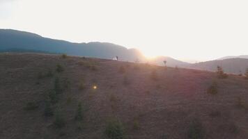 Newlyweds dancing on a high slope of the mountain. Groom and bride. Aerial view video