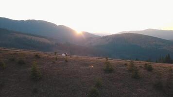 Newlyweds running on a high slope of the mountain. Groom and bride. Aerial view video