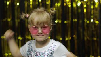 Funny child trying to fight at camera, boxing with expression. Girl posing on shiny background video