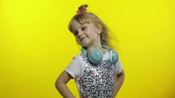 Child with headphones, showing thumb up. Relaxing, enjoying, having hun on yellow background video