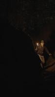 Embarking on a journey through dark caves illuminated by a flickering light at night video