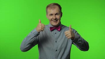 Man showing thumbs up sign, smiling, laughing, satisfied with excellent result, good service video