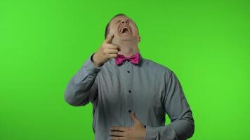 Man pointing finger and laughing out loud, holding belly with hilarious laughter, making fun, joke video