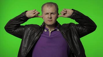 Don't want listen. Rocker man covering ears with arms not to hear annoying talk, ignoring conflict video