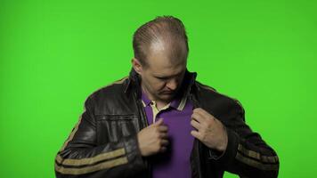 Brutal rocker man taking out heart gesture from his jacket and demonstrating romantic emotions video