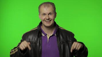 Man rocker asking to subscribe, trying to control, pointing fingers down. Chroma key background video