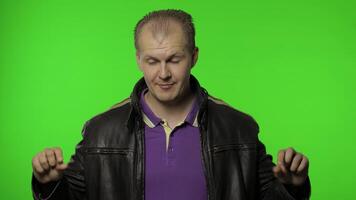 Man rocker asking to subscribe, trying to control, pointing fingers down. Chroma key background video