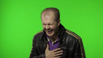 Man holding belly and laughing out loud with tears, feeling carefree joyful after hearing funny joke video