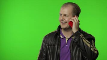 Rocker man calling friend, talking on mobile phone with proud expression, speaking emotionally video