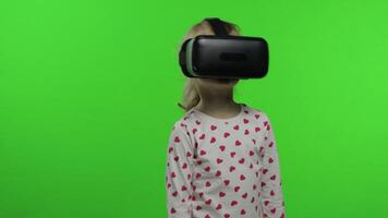 Child girl using VR helmet to play simulation game app. Watch virtual reality 3d . Chroma key video