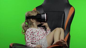 Child girl using VR headset helmet to play game. Watching virtual reality 3d 360 . Chroma key video