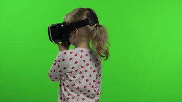 Child girl using VR headset helmet to play game. Watching virtual reality 3d 360 . Chroma key video