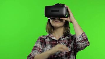 Girl using VR app helmet to play simulation game. Slide gestures. Watching virtual reality 3d video