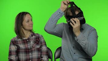 Man and woman using VR headset helmet to play game. Watching virtual reality 3D . Chroma key video