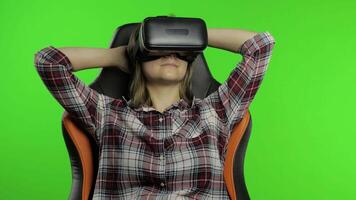 Young woman using VR headset helmet to play game. Watching virtual reality 3d 360 . Chroma key video