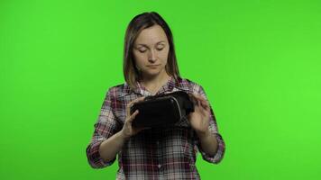 Young woman using VR headset helmet to play game. Watching virtual reality 3d 360 . Chroma key video