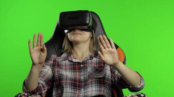 Young woman using VR headset helmet to play game. Watching virtual reality 3d 360 . Chroma key video