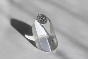 minimalista plata colgante con un único geométrico modelo en un blanco antecedentes. hecho a mano joyas. foto