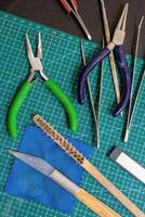 Overhead view on tools on a green cutting mat for crafting handmade jewelry things. photo