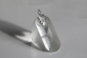 elegante y minimalista plata colgante con delicado diseño hoja de monstera en un limpiar blanco antecedentes. foto