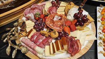 Cheese platter and bite size foods including sushi bar decorated on a table for a party photo