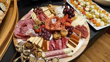 Cheese platter and bite size foods including sushi bar decorated on a table for a party photo