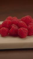 A beautiful arrangement of Fresh Raspberries on a pristine White Plate for presentation video