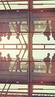 Silhouettes in an urban setting show interactions amidst light reflecting on architecture video