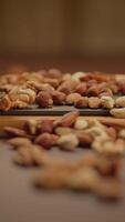 A variety of assorted nuts beautifully spread out on a rustic wooden surface for display video